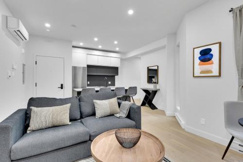 a living room with a gray couch and a table at Deluxe Suites Downtown Montreal in Montréal