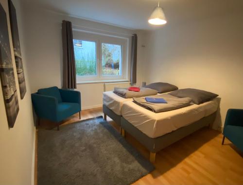 1 dormitorio con 2 camas y silla azul en Osthafen III, en Berlín