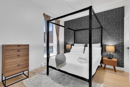 a bedroom with a black and white canopy bed at Deluxe Suites Downtown Montreal in Montréal