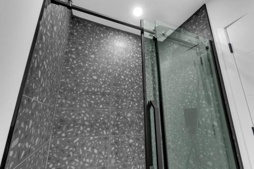 a shower stall with a glass door with a ceiling at Deluxe Suites Downtown Montreal in Montréal