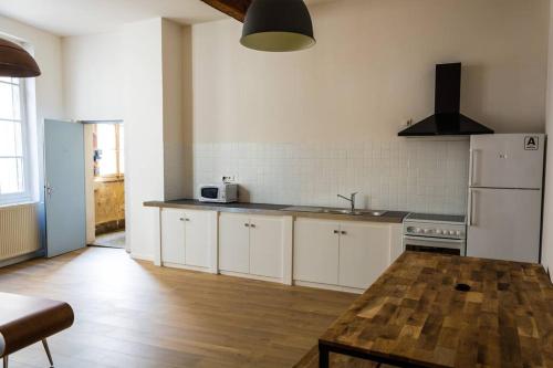 cocina con armarios blancos y mesa de madera en Apartment in hyper center - 3 bedrooms en Arles