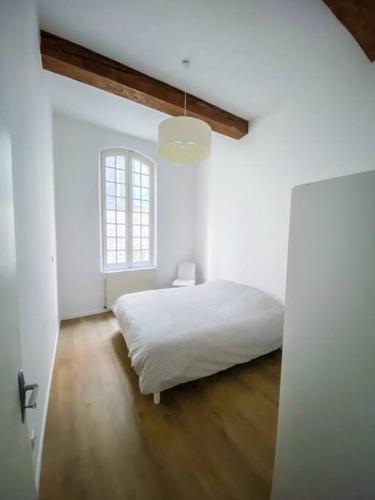une chambre blanche avec un lit et une fenêtre dans l'établissement Apartment in hyper center - 3 bedrooms, à Arles