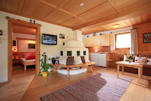 a living room with a kitchen with a stove in it at Familienfreundliches Apartmenthaus Thuss`n, ruhige Lage, im Herzen der Wanderregion Kitzbüheler Alpen und MTB Trails in Kirchberg in Tirol