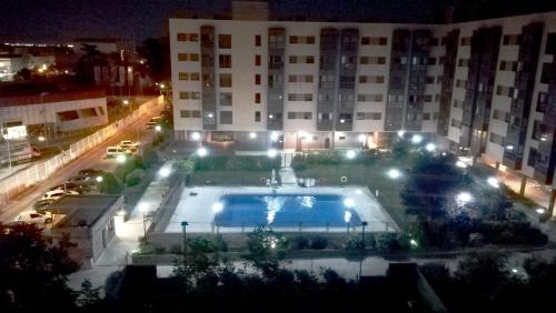 a swimming pool in front of a building at night at Adolfo Suárez Madrid apartments in Madrid