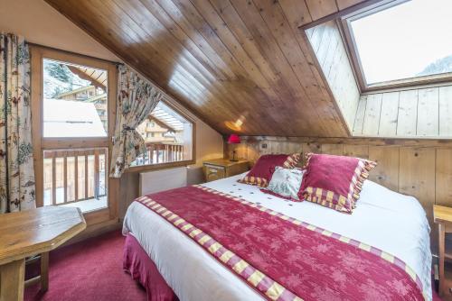 a bedroom with a bed and a wooden ceiling at Hotel Eterlou in Méribel