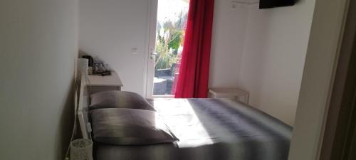 a bed in a room with a red curtain at La Halte Gourmande in Vachères