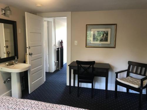 - une chambre avec un bureau, un lavabo et un lit dans l'établissement Windsor Guest House, à Vancouver