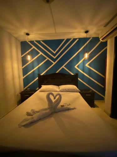 a bed with two swans in the shape of a heart at Residencias Piscis in Barranquilla