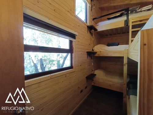 a room with bunk beds and a window at Refugio Nativo in Nevados de Chillan
