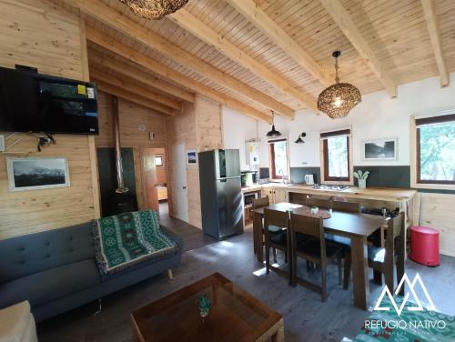 a kitchen and living room with a couch and a table at Refugio Nativo in Nevados de Chillan