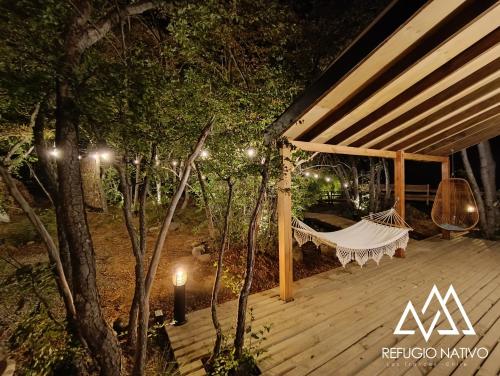 a hammock on a deck at night at Refugio Nativo in Nevados de Chillan