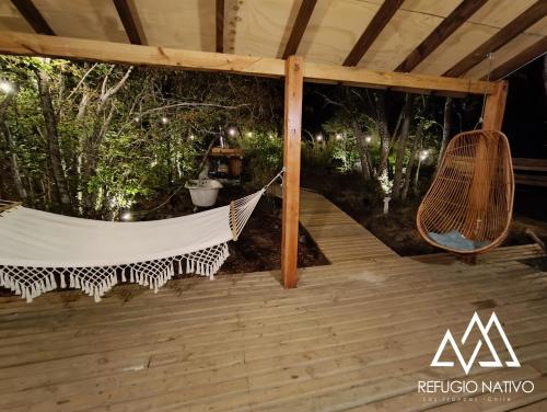 a hammock on a deck in a tent at Refugio Nativo in Nevados de Chillan