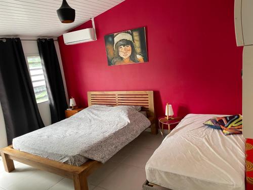 a bedroom with a red wall with a bed at Tampok lodge in Cayenne