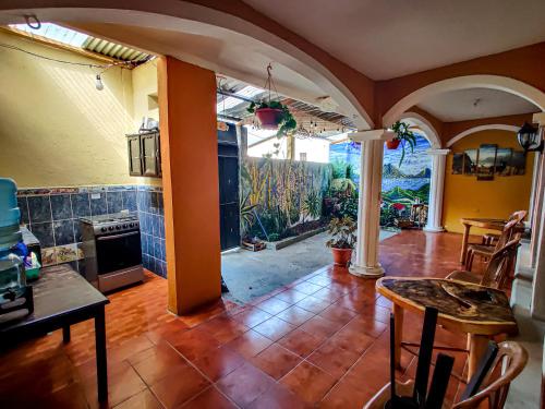 a living room with a table and a kitchen at Casa Argentina in San Juan La Laguna