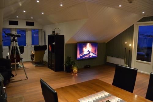 a room with a table and a tv on the wall at Arctic Sea house in Svensby