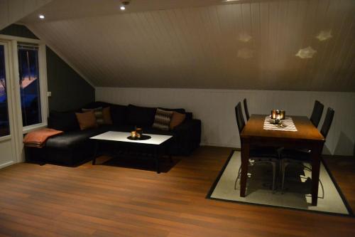 a living room with a couch and a table at Arctic Sea house in Svensby
