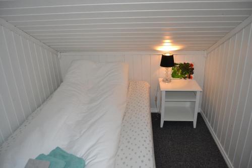a small bedroom with a bed and a table at Arctic Sea house in Svensby