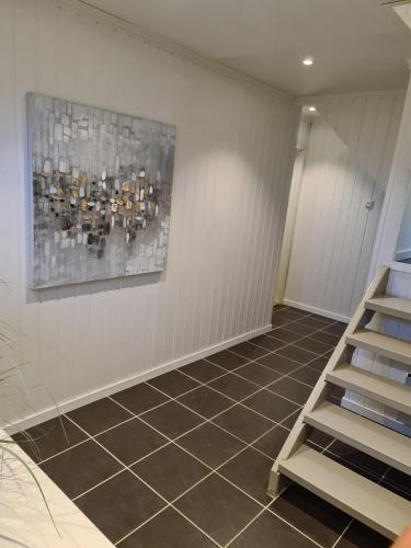 a room with a tile floor and a painting on the wall at Arctic Sea house in Svensby