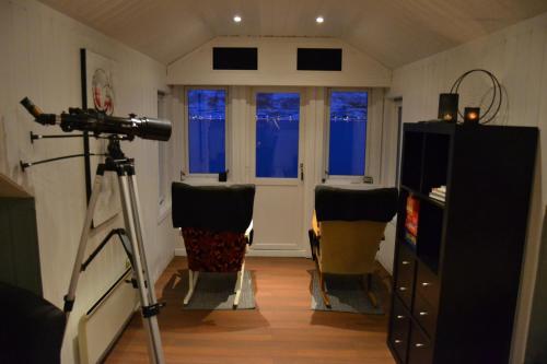 a camera in a room with two chairs and a door at Arctic Sea house in Svensby