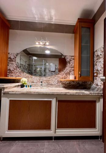 a kitchen with a counter with a sink and a mirror at New Museum Guest House, Pyramids View in Cairo