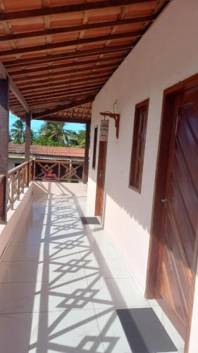 a porch of a house with a wooden roof at Pousada Recanto das Flores in Praia de Moitas