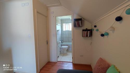 a hallway with a bathroom with a toilet and a sink at Casita de Sara in Castro
