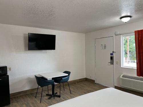 Habitación con cama, mesa y sillas. en Motel 6-Orange, CA - Anaheim, en Anaheim