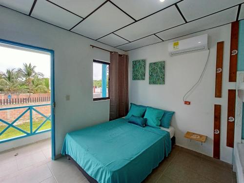 a bedroom with a bed and a large window at Cabañas Cigua in Coveñas