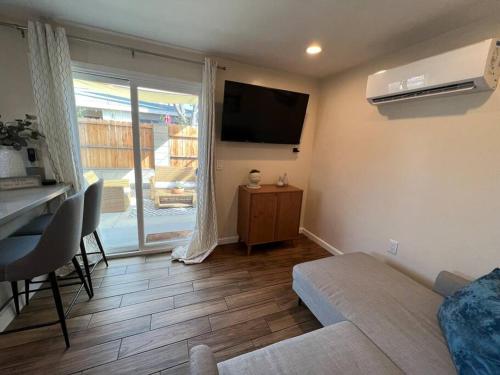 a living room with a couch and a television on the wall at La Casita de Whittier, Private Unit w/patio area, Disney, Biola, Knotts in Whittier