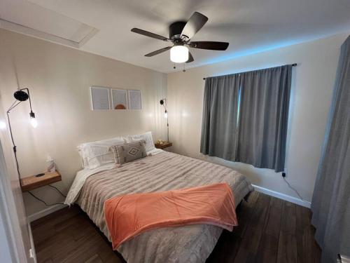 ウィッティアにあるLa Casita de Whittier, Private Unit w/patio area, Disney, Biola, Knottsのベッドと天井扇風機のある寝室