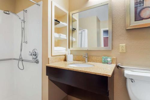 a bathroom with a sink and a mirror and a toilet at Best Western Natchitoches Inn in Natchitoches