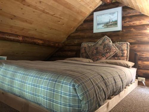 a bedroom with a bed in a log cabin at Morning Star Log Cabin in Nelson
