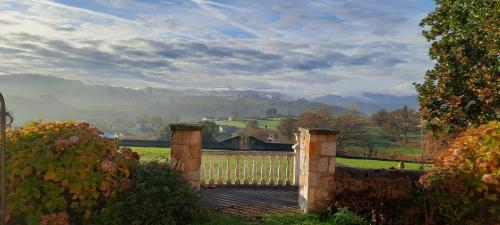 a wooden gate with a view of a valley at Palacio Marqués Vega de Anzo - Villa de campo sXVII in Siero
