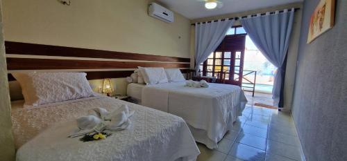 - une chambre d'hôtel avec 2 lits fleuris dans l'établissement Hotel Pousada Sol & Lua, à Paracuru