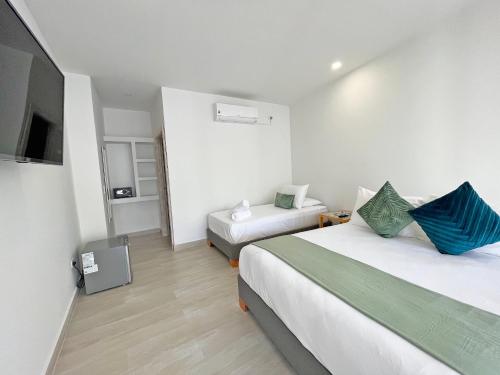 a hotel room with two beds and a television at Zaba Beach House in San Andrés