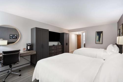 a hotel room with two beds and a desk at Revival Scottsdale Studios in Scottsdale
