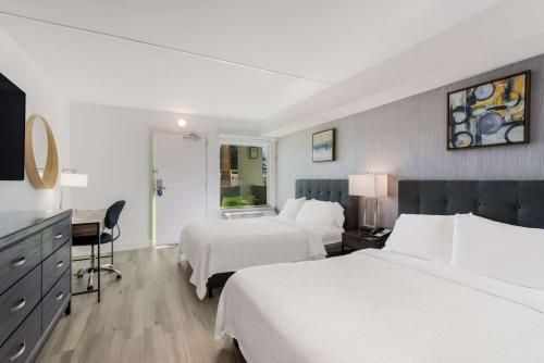 a hotel room with two beds and a desk at SureStay Plus Hotel by Best Western Scottsdale North in Scottsdale