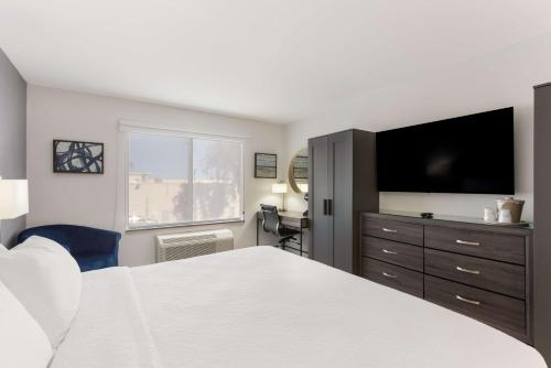 a bedroom with a bed and a flat screen tv at Revival Scottsdale Studios in Scottsdale