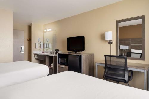 a hotel room with two beds and a television at SureStay Hotel by Best Western Wells in Wells