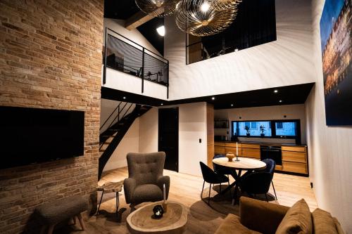 a living room with a couch and a table with chairs at Broncks Lonin - Luxury Apartments in the Heart of Tórshavn in Tórshavn