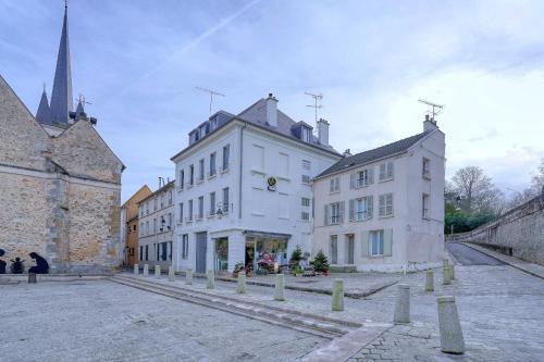 a group of buildings on a street with a church at Confort et Nature, Duplex Idéal à Jouy-en-Josas, Parking gratuit, 25 mn orly, 10 mn Versailles in Jouy-en-Josas