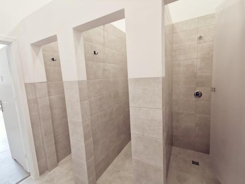 La salle de bains est pourvue d'une douche avec du carrelage beige. dans l'établissement Komfortowa kwatera, à Stęszew
