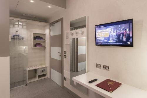a bathroom with a tv hanging on the wall at Hotel Doge in Vicenza