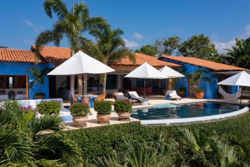 eine Villa mit einem Pool und Sonnenschirmen in der Unterkunft Casa Aries in Costa Careyes