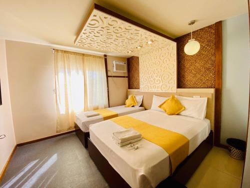 Villa Rosita Hotel في نجا: غرفة فندقية بسريرين ونافذة
