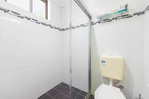 a bathroom with a toilet and a glass shower at Plainsman Motel in Forbes