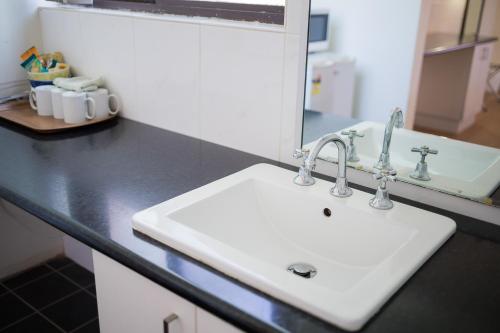 a bathroom counter with a white sink and a mirror at Plainsman Motel in Forbes