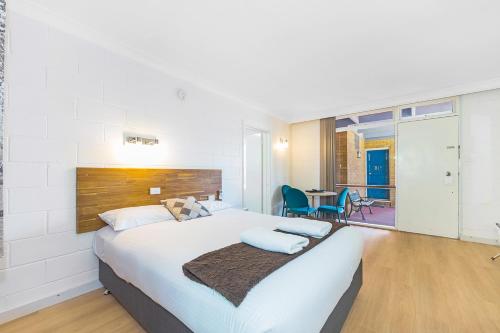 a bedroom with a large bed and a table at Plainsman Motel in Forbes