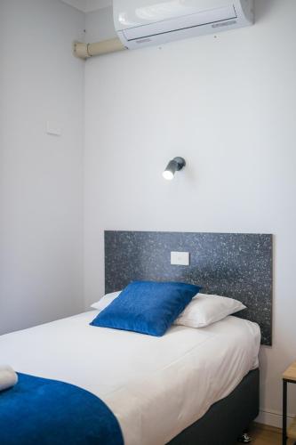 a bed with a blue pillow on top of it at Plainsman Motel in Forbes
