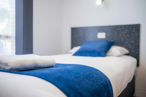 a bedroom with two beds with blue pillows at Plainsman Motel in Forbes